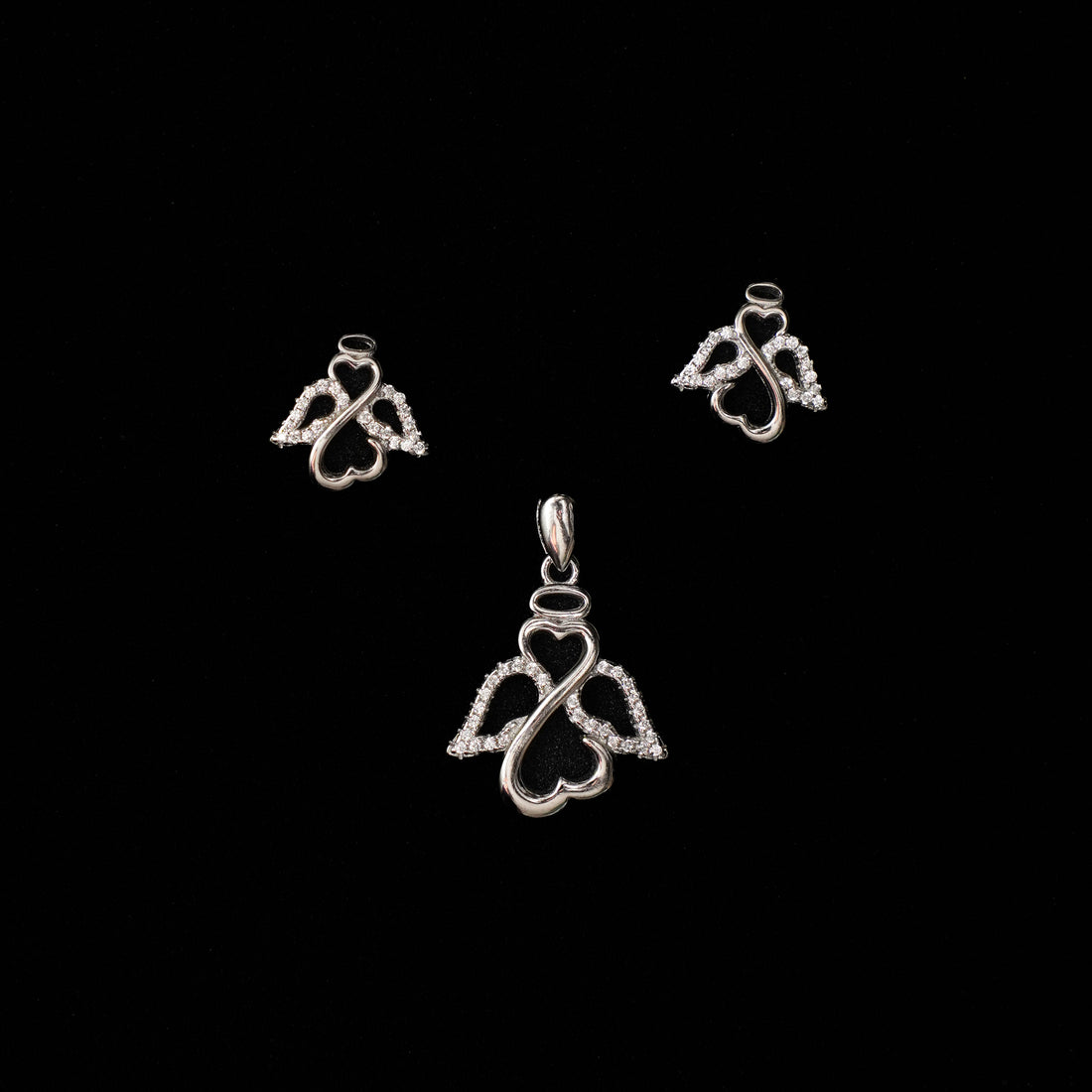 Set of silver heart-shaped pendants on a black background