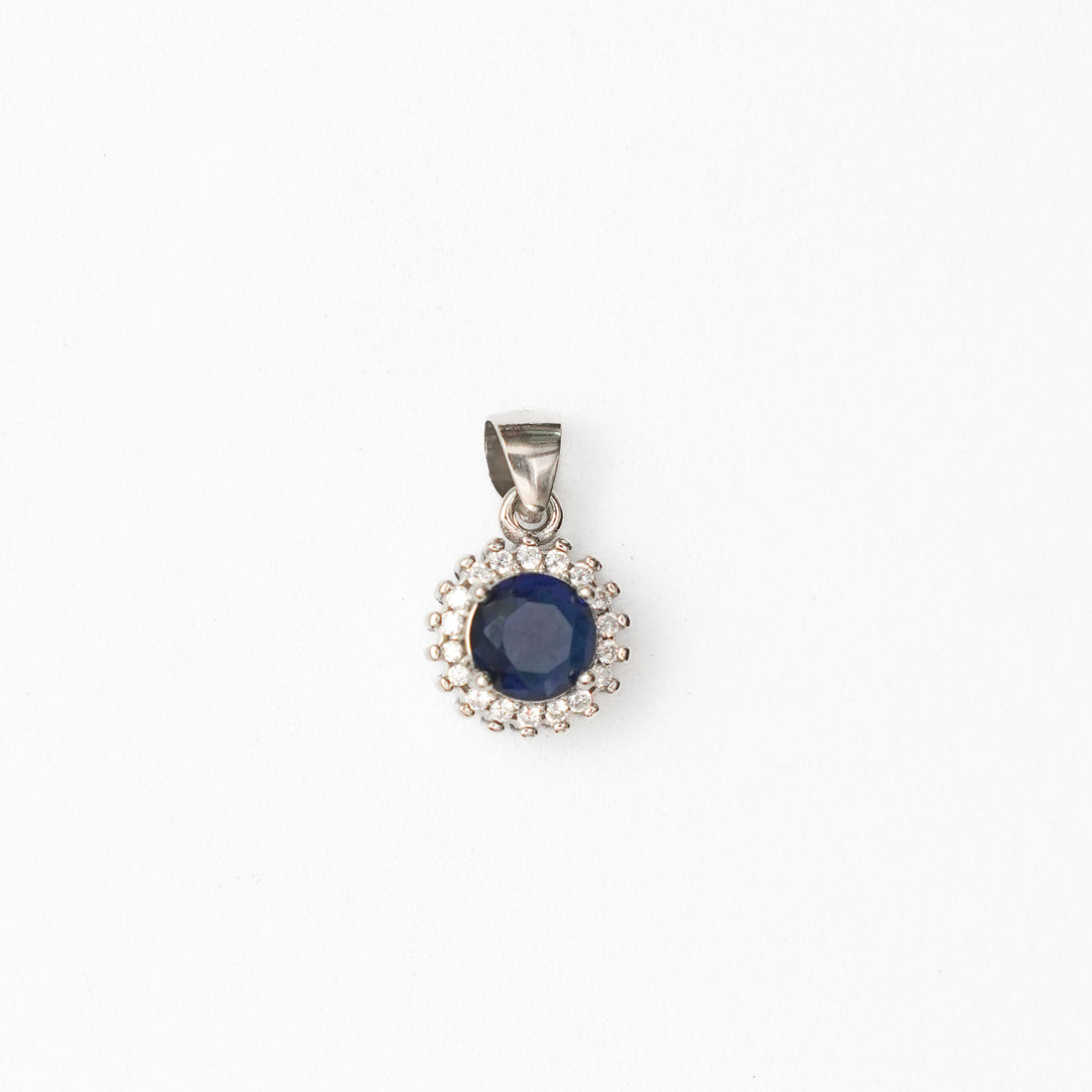 Silver pendant with a blue gemstone on a white background