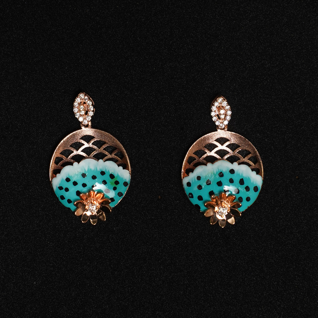 Pair of earrings with turquoise circular design and gold accents on a black background